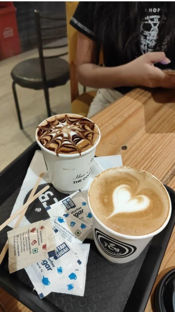 Takeaway cups with latte art on a tray